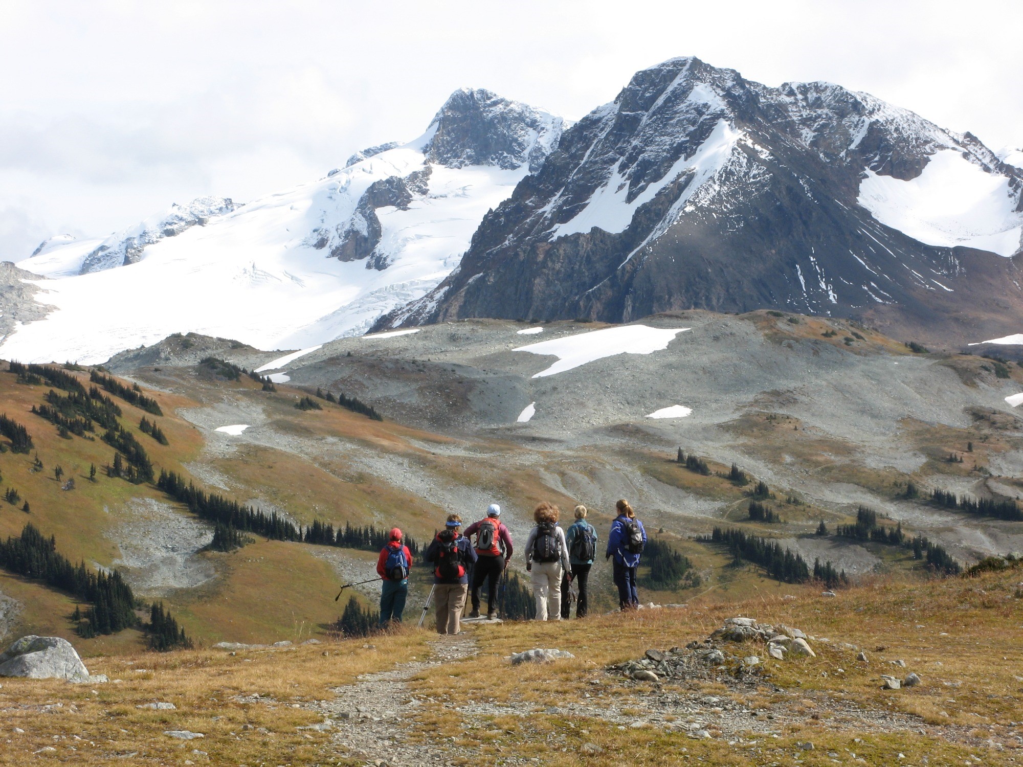 Vancouver Outdoor Club for Women members looking at snow-capped mountains in the distance along Singing Pass in Garibaldi Provincial Park