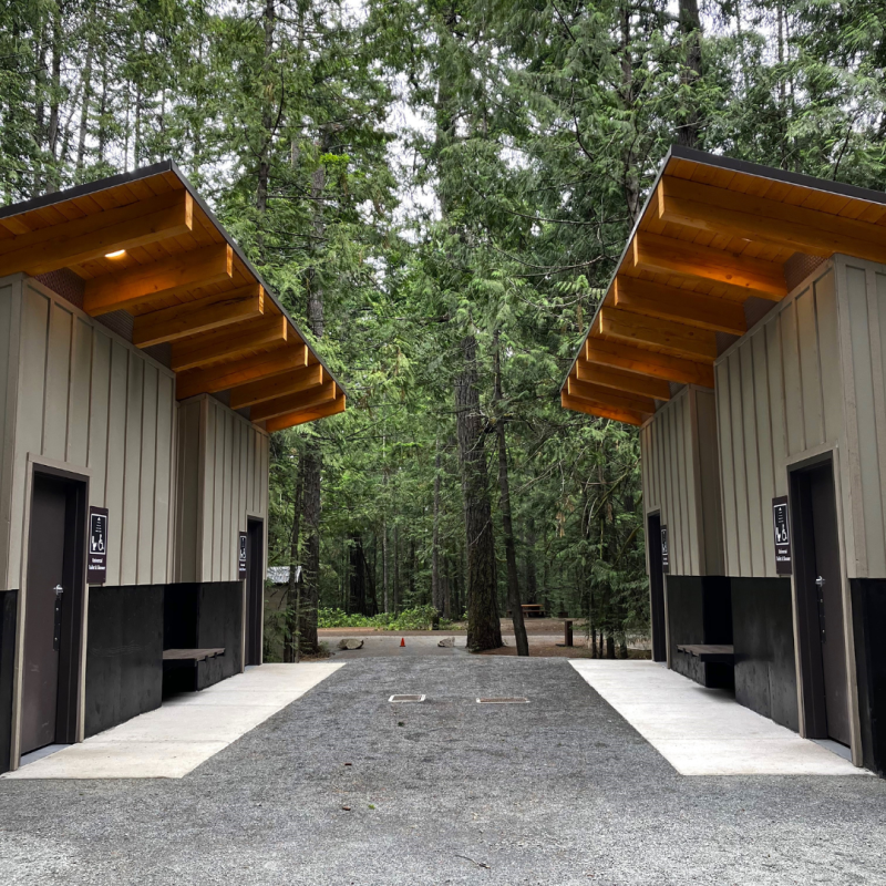 Photo of two modern outdoor washroom and shower facilities across from each other.  